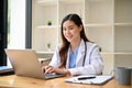 An Asian female doctor working on her medical research on laptop in her hospital office Royalty Free Stock Photo