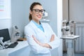 attractive professional ophthalmologist in glasses standing with crossed arms