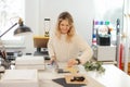 Professional smiling blond woman in sweater worker using printer cutter in workshop. Print office. Carving sheets paper Royalty Free Stock Photo