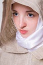 Attractive pure girl with a clear look in a white scarf addresses prayer to God