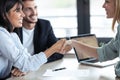 Attractive real-estate agent shaking hands with young couple after signing agreement contract in the office Royalty Free Stock Photo