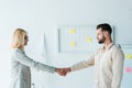 Recruiter in glasses and handsome employee shaking hands