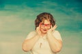 Attractive red-haired plump woman in a white suit adjusts red glasses on a blue background Royalty Free Stock Photo