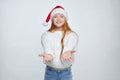 Attractive red-haired teenage girl in a Santa hat. The concept of Christmas and New year. photo session in the Studio on a white