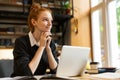 Attractive red haired teenage girl using laptop computer Royalty Free Stock Photo