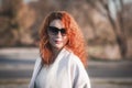 Attractive red-haired woman in sunglasses and a coat Royalty Free Stock Photo