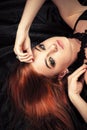 Attractive redhead girl with fashionable makeup lying down