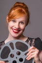 Attractive redhead holding film reel