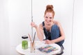 Attractive redhead is painting with water colours at home Royalty Free Stock Photo