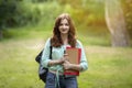 Attractive redhead student girl with backpack and workbooks posing at campus yard Royalty Free Stock Photo