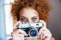 Attractive redhead woman photographer using old camera Royalty Free Stock Photo