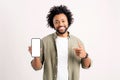 Attractive 30s african-american man pointing finger at smartphone with blank empty screen standing isolated on white Royalty Free Stock Photo