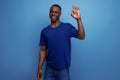 attractive 25s african guy in casual blue t-shirt showing finger ok