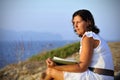 Attractive 40s mature woman reading and looking at horizon pensive Royalty Free Stock Photo