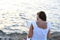 Attractive 40s woman sitting alone on the beach reading a book Royalty Free Stock Photo