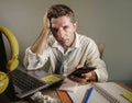 Attractive sad and desperate man in lose necktie looking messy and depressed working at laptop computer desk in business office pr Royalty Free Stock Photo