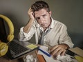 Attractive sad and desperate man in lose necktie looking messy and depressed working at laptop computer desk in business office pr Royalty Free Stock Photo