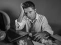 Attractive sad and desperate man in lose necktie looking messy and depressed working at laptop computer desk in business office pr Royalty Free Stock Photo