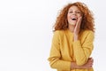 Attractive sassy and feminine redhead woman with curly hair, wear yellow sweater, laughing arrogant and pleased