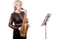 Attractive saxophonist woman playing at her musical instrument