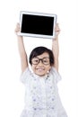 Attractive schoolgirl lifts digital tablet