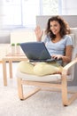 Attractive schoolgirl using laptop at home smiling Royalty Free Stock Photo