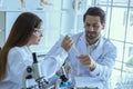 Attractive scientist medical worker with sample test tube at laboratory , doing a analysis in a laboratory doing research to Royalty Free Stock Photo