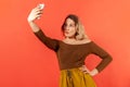 Attractive self confident woman blogger making selfie, posing to camera of her smartphone Royalty Free Stock Photo