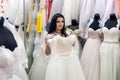 Attractive seller in bridal salon with wedding dresses