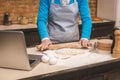 Attractive senior aged woman is cooking on kitchen. Grandmother making tasty baking. Using laptop. Close-up food concept Royalty Free Stock Photo