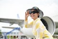 An attractive senior Asian lady in a summer outfit stands at the airport Royalty Free Stock Photo