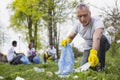 Attractive senior volunteer picking up trash