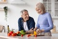 Attractive senior woman cooking and talking to husband Royalty Free Stock Photo