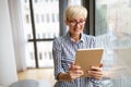 Attractive senior woman using a tablet computer relaxing at home Royalty Free Stock Photo