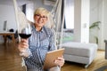 Attractive senior woman using a tablet computer relaxing at home Royalty Free Stock Photo