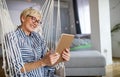 Attractive senior woman using a tablet computer relaxing at home Royalty Free Stock Photo