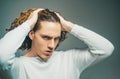 Attractive sensual guy poses in white t-shirt. Man with confident face and brutal style. Copyspace. In casual light t Royalty Free Stock Photo