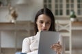 Attractive serious woman spend leisure at home using digital tablet Royalty Free Stock Photo