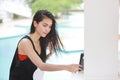 Attractive and sexy asian girl in orange bikini and black suit start using cell phone for live or do chatting with beauty face Royalty Free Stock Photo