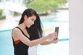 Attractive and sexy asian girl in orange bikini and black suit start using cell phone for live or do chatting with beauty face Royalty Free Stock Photo