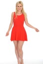 Attractive Playful Young Blonde Woman Wearing a Short Red Mini Dress Royalty Free Stock Photo