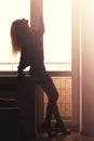 Attractive woman with slender body is standing near the window Royalty Free Stock Photo