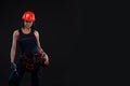 Attractive young woman doing repairs at black background. Portrait of a female construction worker. Building, repair concept. Copy Royalty Free Stock Photo