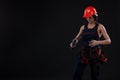 Attractive young woman doing repairs at black background. Portrait of a female construction worker. Building, repair concept. Copy Royalty Free Stock Photo