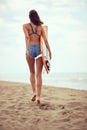 Attractive sexy woman walking on beach with surfboard in hands Royalty Free Stock Photo