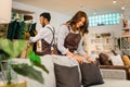 attractive shopkeeper woman arranges sofa cushions with her friend after opening