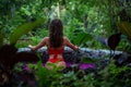 Attractive slim girl is standing back in the jungle. Brunette model in in the pool of flowers. Spa, relaxing. model