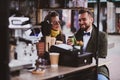 Attractive smart couple is enjoying coffee while sitting outside at small coffeesho