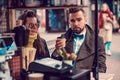 Attractive smart couple is enjoying coffee while sitting outside at small coffeesho