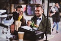 Attractive smart couple is enjoying coffee while sitting outside at small coffeesho